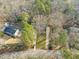 An aerial view of the home nestled between mature trees with a long driveway leading to a lush front lawn at 5620 Winthrop Dr, Raleigh, NC 27612