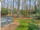 A view of the expansive, partially-wooded backyard with a grey deck, providing a serene outdoor space at 5620 Winthrop Dr, Raleigh, NC 27612