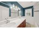 Bright bathroom features dual sinks, modern lighting, and classic tiled shower and tub at 5620 Winthrop Dr, Raleigh, NC 27612