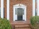 Close-up of the front door with decorative sidelights and brickwork, showcasing the home's entrance at 5620 Winthrop Dr, Raleigh, NC 27612