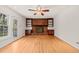 Living room with brick fireplace, built-in shelving, and hardwood floors at 5620 Winthrop Dr, Raleigh, NC 27612