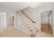 Elegant staircase with white spindles and wood railing, complemented by a chandelier at 5620 Winthrop Dr, Raleigh, NC 27612