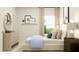 Cozy bedroom with decorative mirror, blue accent blanket, side tables and bright window at 616 Emerald Bay Cir, Raleigh, NC 27610