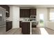 Stylish kitchen with island seating, stainless steel refrigerator and dark wood cabinets at 616 Emerald Bay Cir, Raleigh, NC 27610