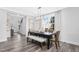 Open-concept dining room with modern table, chairs, bench, wood floors, and natural light at 625 Emerald Bay Cir, Raleigh, NC 27610