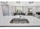 Island with a stainless steel dual sink faucet, wood floors, and open view of the dining and living area at 625 Emerald Bay Cir, Raleigh, NC 27610