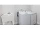 Well-lit laundry room featuring a utility sink, washer, and dryer for added convenience at 625 Emerald Bay Cir, Raleigh, NC 27610