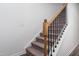 Staircase with carpeted steps, wooden handrail, and black metal balusters at 68 Commons Cir # 223, Clayton, NC 27520