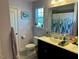 Well-lit bathroom featuring a window, double sink, and shower with forest-themed curtain at 70 Maxwell Pl, Lillington, NC 27546