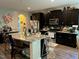 Spacious kitchen with granite countertops, dark cabinets, stainless steel appliances, and a center island at 70 Maxwell Pl, Lillington, NC 27546