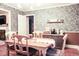 Cozy dining area with patterned wallpaper, classic wooden table, and custom storage at 711 Stuart Dr, Sanford, NC 27330