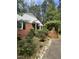 Charming front yard featuring a brick facade, blooming roses and an arbor entrance at 711 Stuart Dr, Sanford, NC 27330