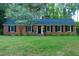 Charming brick home featuring a manicured lawn and classic black shutters at 711 Stuart Dr, Sanford, NC 27330