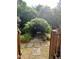 A verdant garden gate leads through stone pavers to a bench beyond at 711 Stuart Dr, Sanford, NC 27330