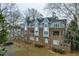 Multi-story building with brick and light blue siding, white windows, gray roof, and landscaped yard at 741 Bishops Park Dr # 204, Raleigh, NC 27605