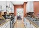 Galley kitchen with stainless appliances, white cabinets and hardwood floors at 741 Bishops Park Dr # 204, Raleigh, NC 27605