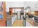 Galley kitchen with stainless appliances, white cabinets, hardwood floors and bar seating at 741 Bishops Park Dr # 204, Raleigh, NC 27605