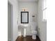 Charming powder room with a pedestal sink, stylish mirror, and natural light from the window at 806 Hyperion Aly, Wake Forest, NC 27587