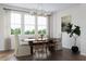 Formal dining room featuring hardwood floors, a modern chandelier, and a large window with natural light at 806 Hyperion Aly, Wake Forest, NC 27587