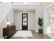 A grand two-story foyer with a decorative glass front door, wood floors, and a modern console table at 806 Hyperion Aly, Wake Forest, NC 27587