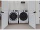 Convenient laundry room with a front-loading washer and dryer, shelving, and easy access through double doors at 806 Hyperion Aly, Wake Forest, NC 27587