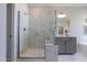 A luxurious bathroom features a glass shower, vanity with gray cabinets, and marble wall tile at 812 Emerald Bay Cir, Raleigh, NC 27610