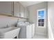 Well-lit laundry room features modern washer and dryer, ample storage cabinets, and a sink at 812 Emerald Bay Cir, Raleigh, NC 27610