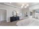 Spacious main bedroom with soft carpet, tray ceiling, decorative lighting, and a sleek black dresser at 812 Emerald Bay Cir, Raleigh, NC 27610