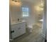 Modern bathroom features quartz counters, shaker cabinets, wood-look flooring, and a shower at 905 Spruce Pine Trl, Durham, NC 27705