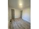 Bedroom with wood-look flooring, neutral walls, base trim, and gray doors at 905 Spruce Pine Trl, Durham, NC 27705