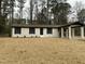 Inviting renovated brick home with a charming covered drive-through, set against a backdrop of mature trees at 905 Spruce Pine Trl, Durham, NC 27705