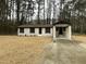Charming renovated home with painted brick and covered porch entrance, enveloped by mature trees at 905 Spruce Pine Trl, Durham, NC 27705
