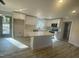 Modern kitchen features white cabinetry, a center island with quartz countertop, stainless appliances, and wood-look flooring at 905 Spruce Pine Trl, Durham, NC 27705