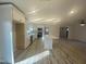 Newly renovated kitchen boasts a central island, modern lighting, stainless appliances, and new wood-look floors at 905 Spruce Pine Trl, Durham, NC 27705