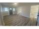 Light-filled living room featuring wood-look flooring, seamlessly connecting to other rooms, with a neutral color scheme at 905 Spruce Pine Trl, Durham, NC 27705