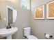Charming bathroom with a pedestal sink, toilet, and decorative artwork at 200 Faith Ave, Sanford, NC 27330