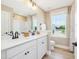 Bright bathroom with a double vanity, framed mirrors, white cabinets, and a window view at 200 Faith Ave, Sanford, NC 27330