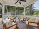 Screened-in porch featuring comfortable seating, a ceiling fan and views of the wooded surroundings at 200 Faith Ave, Sanford, NC 27330