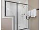 Modern bathroom shower with white subway tile, black trim, glass door, and bronze fixtures at 200 Faith Ave, Sanford, NC 27330