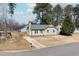 A single-story home with a gray exterior, yellow door, a well-kept lawn and ample parking space at 101 Longneedle Ct, Raleigh, NC 27603