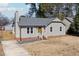 A quaint single-story home featuring gray siding, a contrasting yellow door, and a welcoming front yard at 101 Longneedle Ct, Raleigh, NC 27603