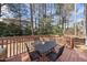 Inviting outdoor back deck with metal table and seating for four, surrounded by trees and nature at 102 Ashley Brook Ct, Cary, NC 27513