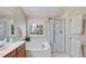 Bright bathroom featuring a soaking tub, glass-enclosed shower, and double sink vanity at 102 Ashley Brook Ct, Cary, NC 27513