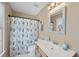 Cozy bathroom features a single vanity with a framed mirror and shower with leaf-patterned curtain at 102 Ashley Brook Ct, Cary, NC 27513