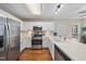 Bright kitchen with stainless steel appliances, updated white cabinetry, and a view into the breakfast nook at 102 Ashley Brook Ct, Cary, NC 27513