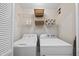 Clean laundry room with washer, dryer, wire shelving, and baskets for organized storage at 102 Ashley Brook Ct, Cary, NC 27513