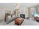Inviting living room with a cozy fireplace, ceiling fan, large windows, and comfortable seating for relaxing at 102 Ashley Brook Ct, Cary, NC 27513