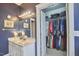 Bright blue bathroom featuring closet access and double sink vanity with modern lighting at 102 Westside Dr, Chapel Hill, NC 27516