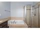 Bathroom featuring a separate soaking tub and glass-enclosed shower with tile surround at 10321 Sablewood Dr # 108, Raleigh, NC 27617