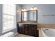 Bathroom with double vanity sinks, granite countertops, and a large framed mirror at 10321 Sablewood Dr # 108, Raleigh, NC 27617
